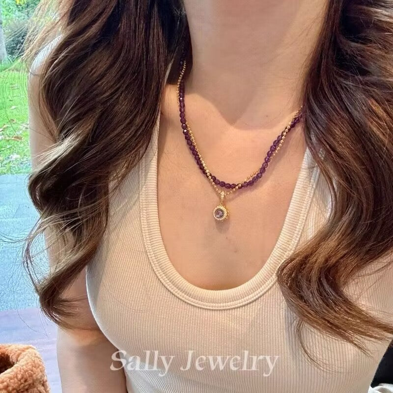 A model wearing the Amethyst Magic Ball Necklace, featuring a vibrant purple amethyst sphere that adds a touch of elegance and charm to their look.