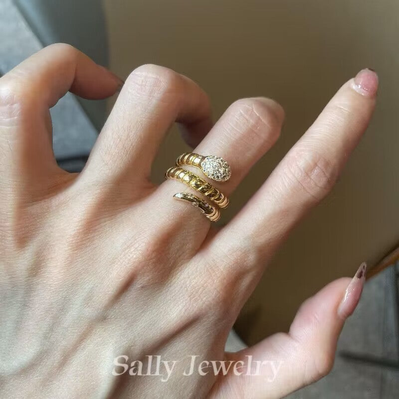 A close-up of the Striped Snake Head Ring worn by a model, highlighting its bold, serpentine design with detailed striped patterns along the band. The ring's snake-head shape creates a striking, edgy look, adding a touch of fierce sophistication to the model's hand.